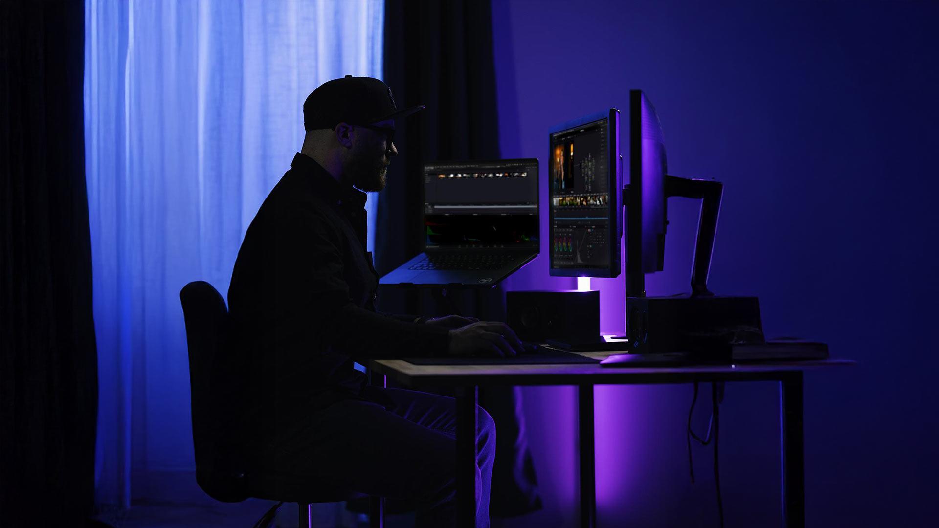 Robin WHR travaillant sur le montage d'un film avec DaVinci Resolve dans son studio vidéo à Rennes, lumière violette, article sur les types de montage cinéma.