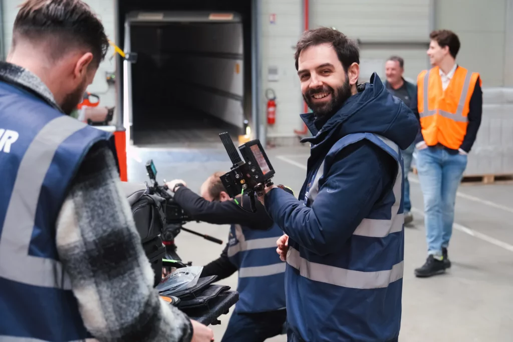 Membres de l’équipe de tournage échangeant près de la caméra dans un entrepôt Le Roy Logistique.