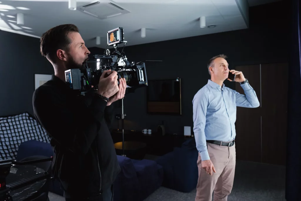 Cadreur filmant un collaborateur au téléphone dans un bureau pendant le tournage du film Le Roy Logistique.