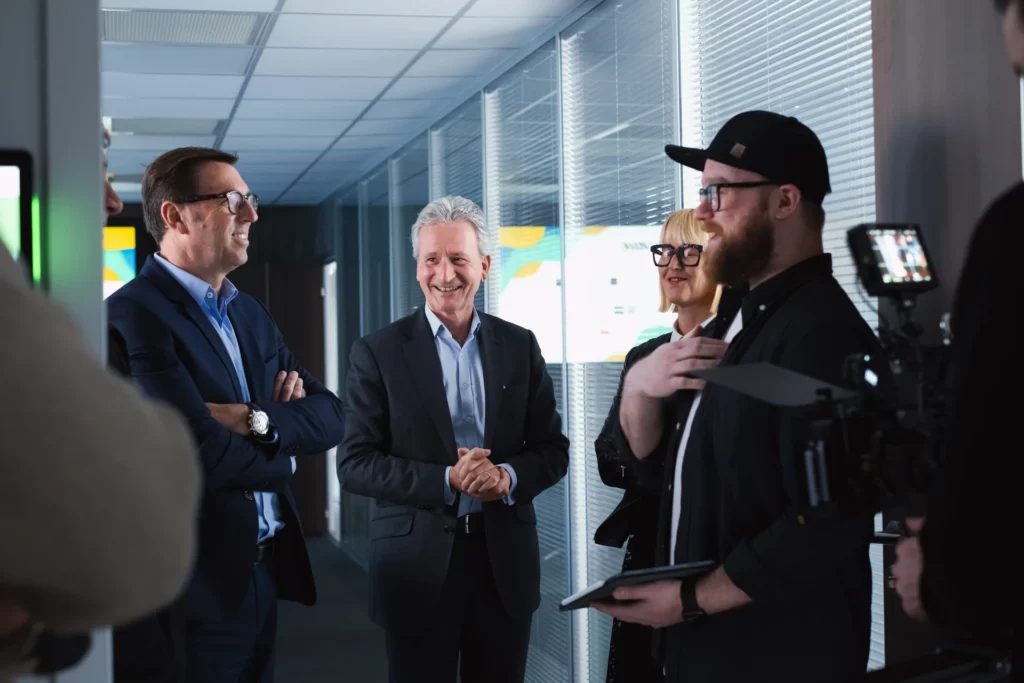 Équipe de tournage préparant une scène avec plusieurs personnes dans les bureaux de Le Roy Logistique.