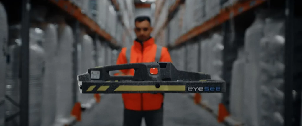 Collaborateur utilisant un appareil de lecture dans une allée de stockage de l’entrepôt Le Roy Logistique.
