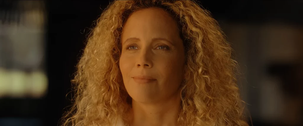 Portrait d’une femme éclairée par la lumière naturelle entrant par la baie vitrée.
