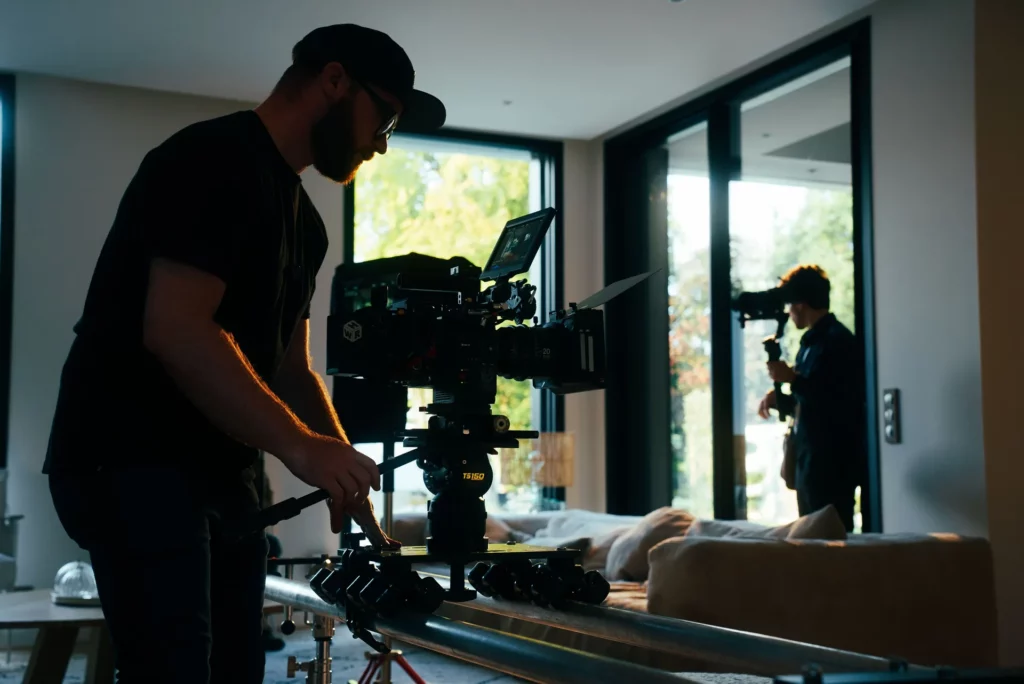 coulisses-campagne-bochassy-equipe-camera Équipe technique autour d’une caméra sur travelling dans le salon de la maison.