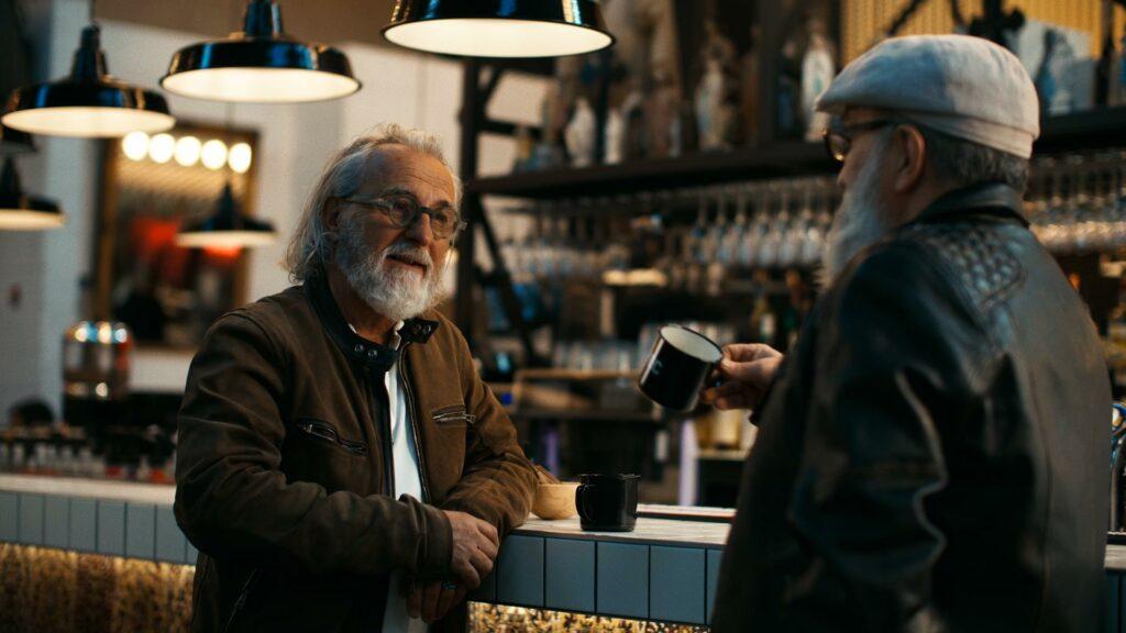 Deux hommes discutant autour d'un café dans un bar, filmé par Robin Welschinger réalisateur à Rennes