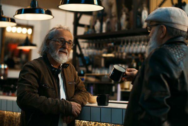 Deux hommes discutant autour d'un café dans un bar, filmé par Robin Welschinger réalisateur à Rennes