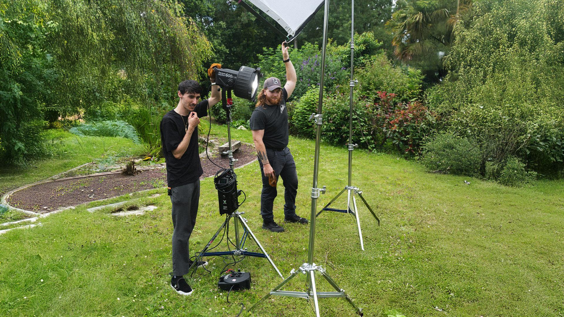 Deux chefs électriciens installent une lumière sur un tournage vidéo dirigé par Robin Welschinger