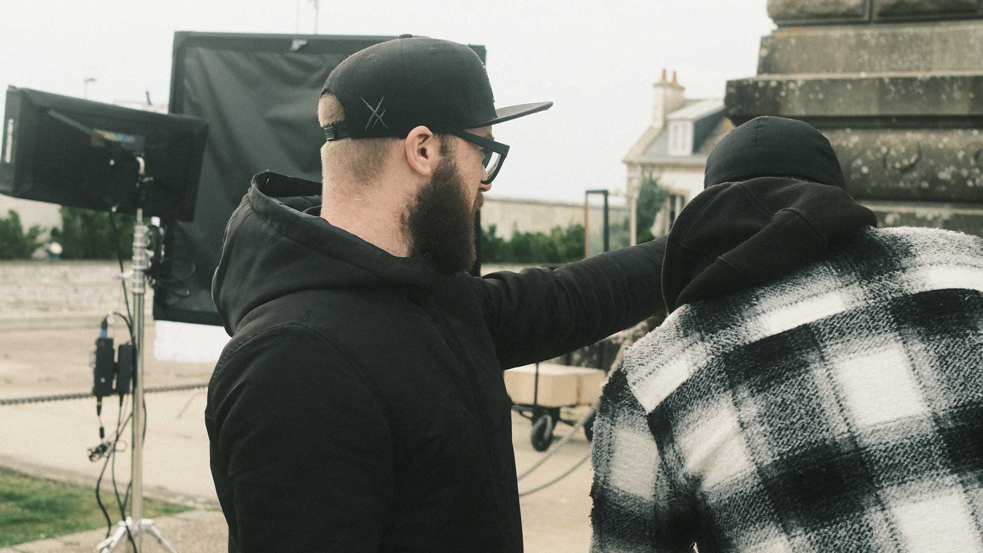 Deux membres d’équipe en repérage et ajustement de mise en scène sur un tournage extérieur