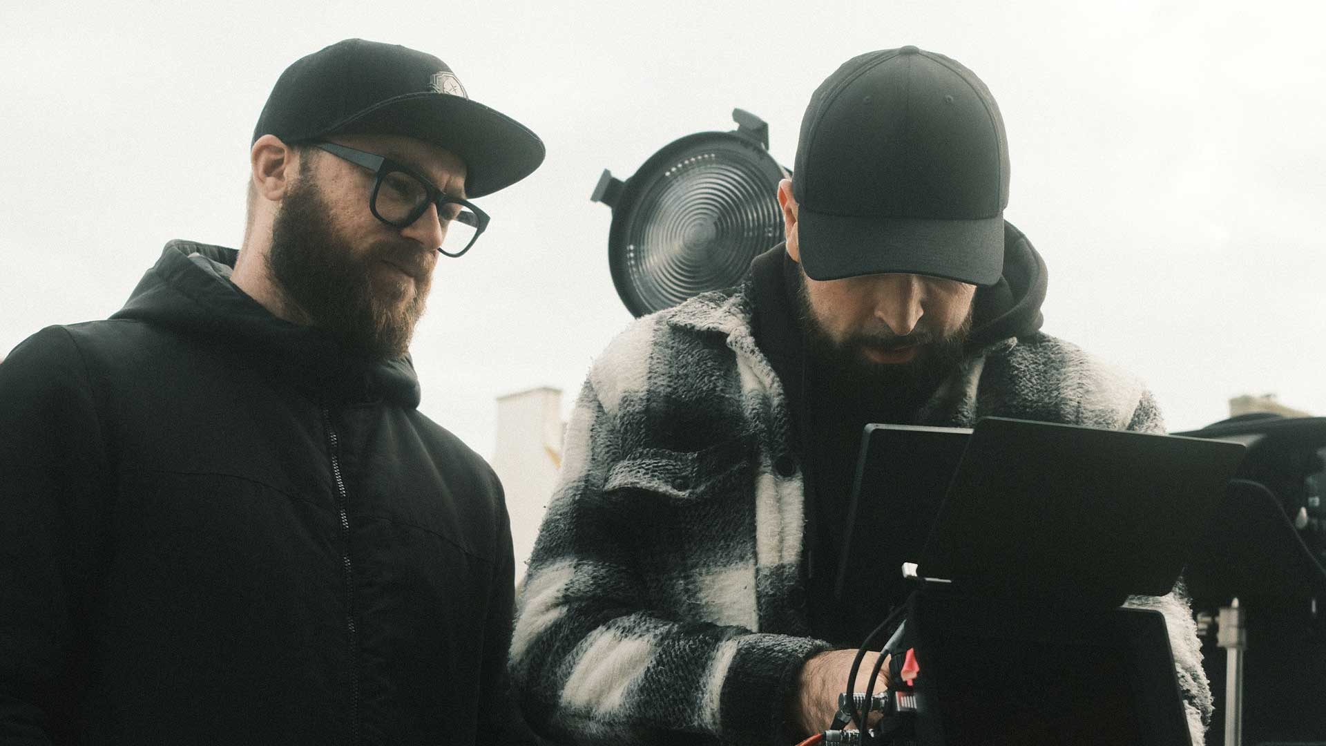 Deux membres d’une équipe vidéo concentrés sur le combo caméra pendant un tournage – Robin Welschinger