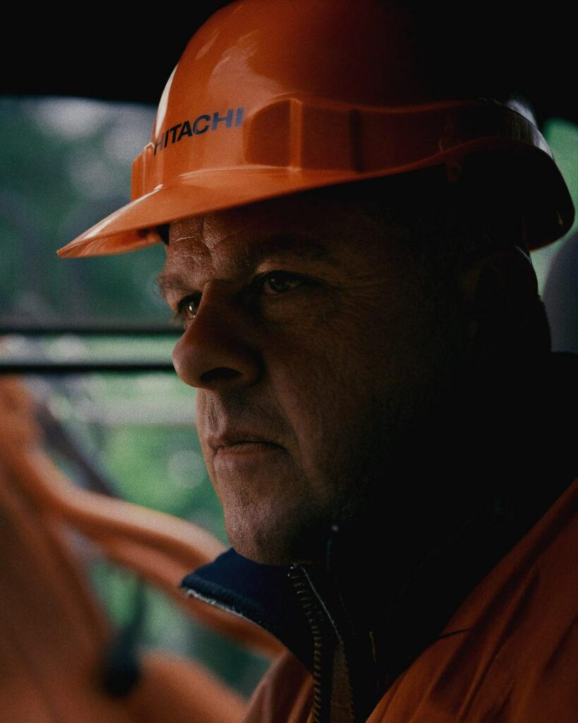 Gros plan sur un ouvrier en casque Hitachi lors du tournage en Bretagne – portrait capté par Robin Welschinger
