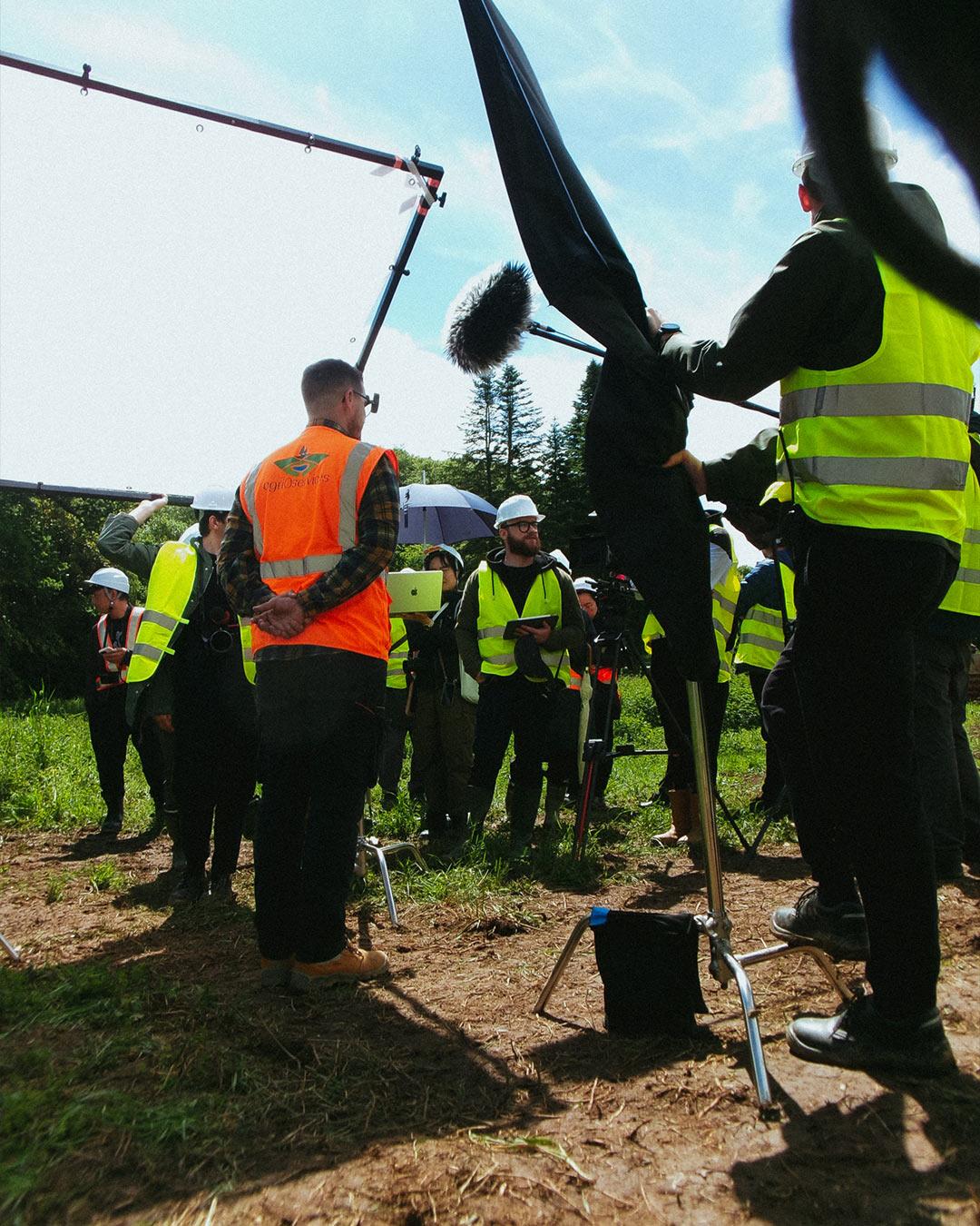 Brief de tournage en extérieur avec l’équipe Hitachi en Bretagne – équipe technique et client en gilet de sécurité, capté par Robin Welschinger