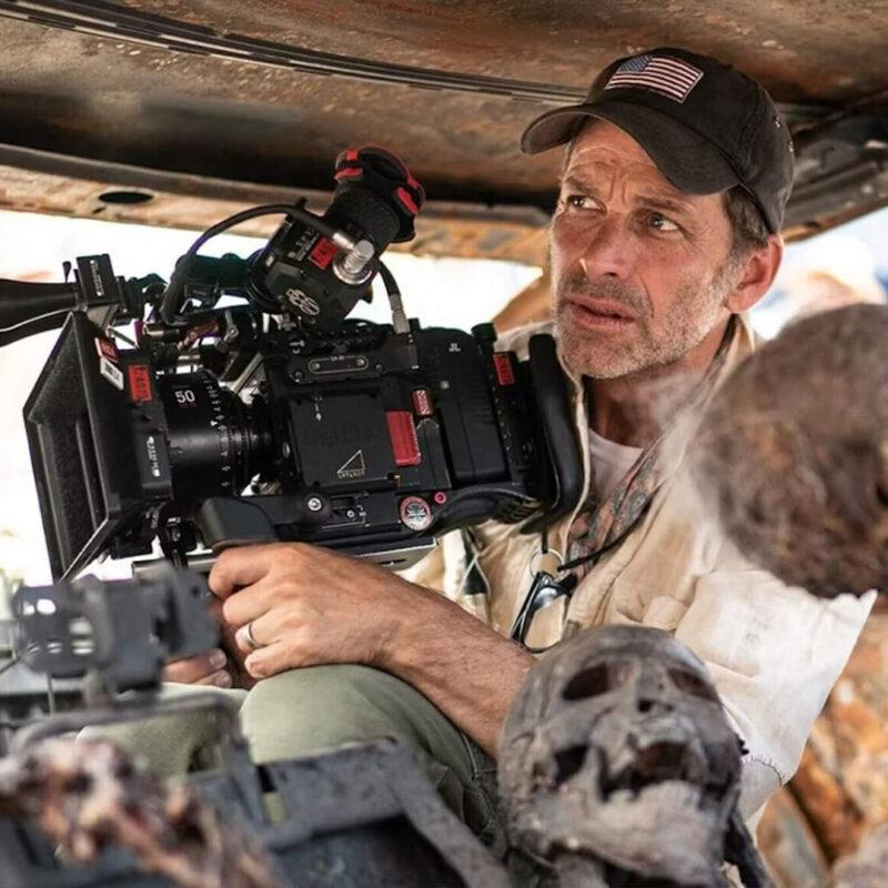 Zack Snyder en tournage, caméra à l’épaule dans un décor post-apocalyptique, illustrant son double rôle de chef opérateur et réalisateur