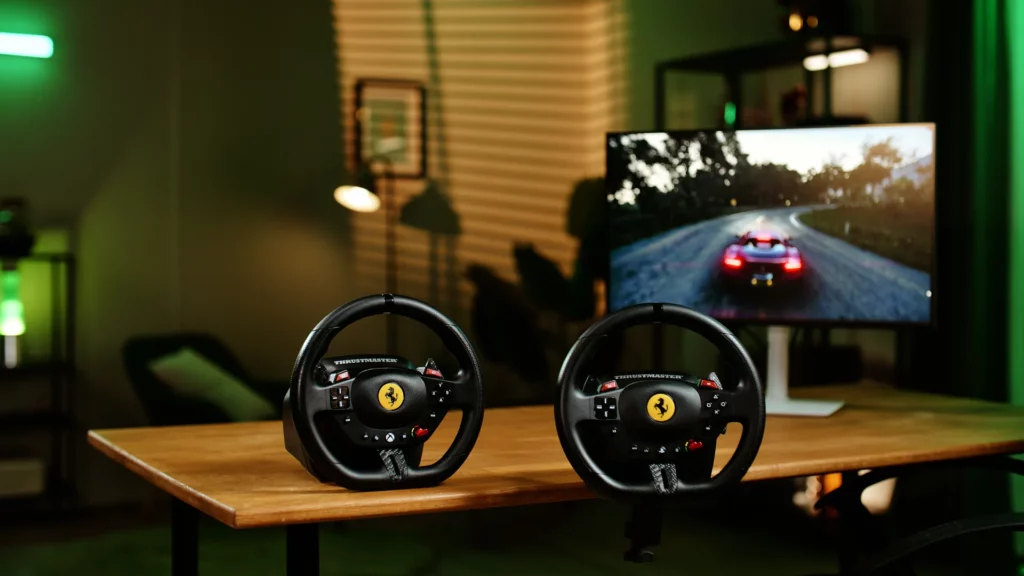 Deux volants gaming Thrustmaster T98 présentés devant un écran de jeu de course dans un décor studio vert.
