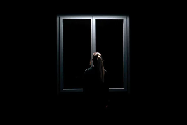 Modèle de dos devant une fenêtre premium Bochassy dans une mise en scène studio noire et minimaliste.