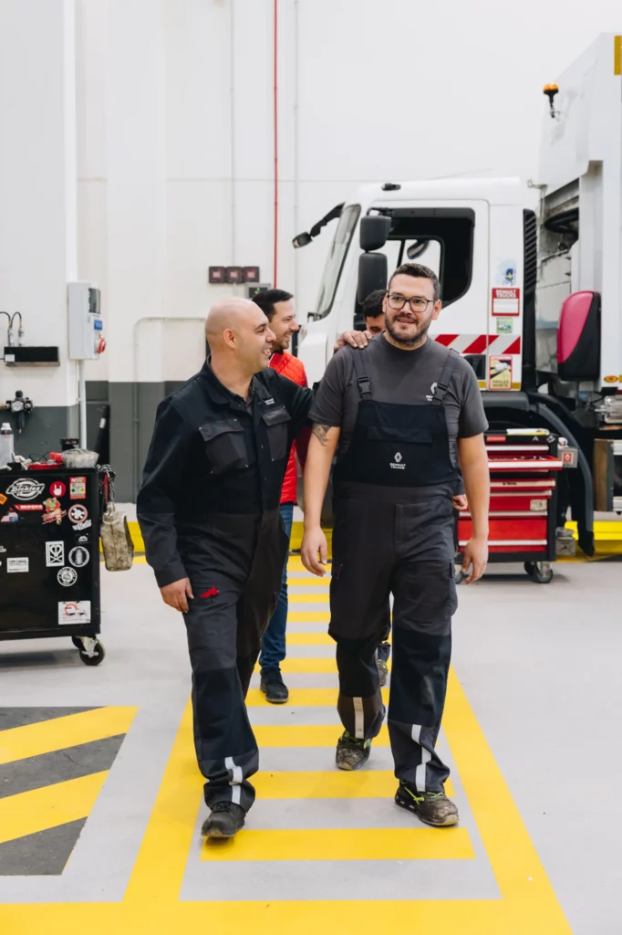 2026-renault-trucks-makers-bts-70 Deux professionnels en tenue de travail marchent dans un atelier Renault Trucks pendant le tournage.