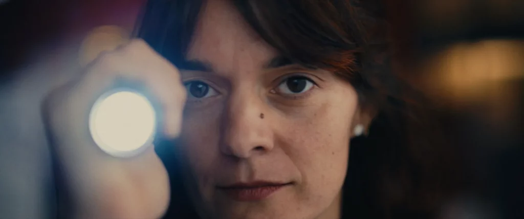 Portrait d’une opératrice éclairée par une lampe d’inspection.
