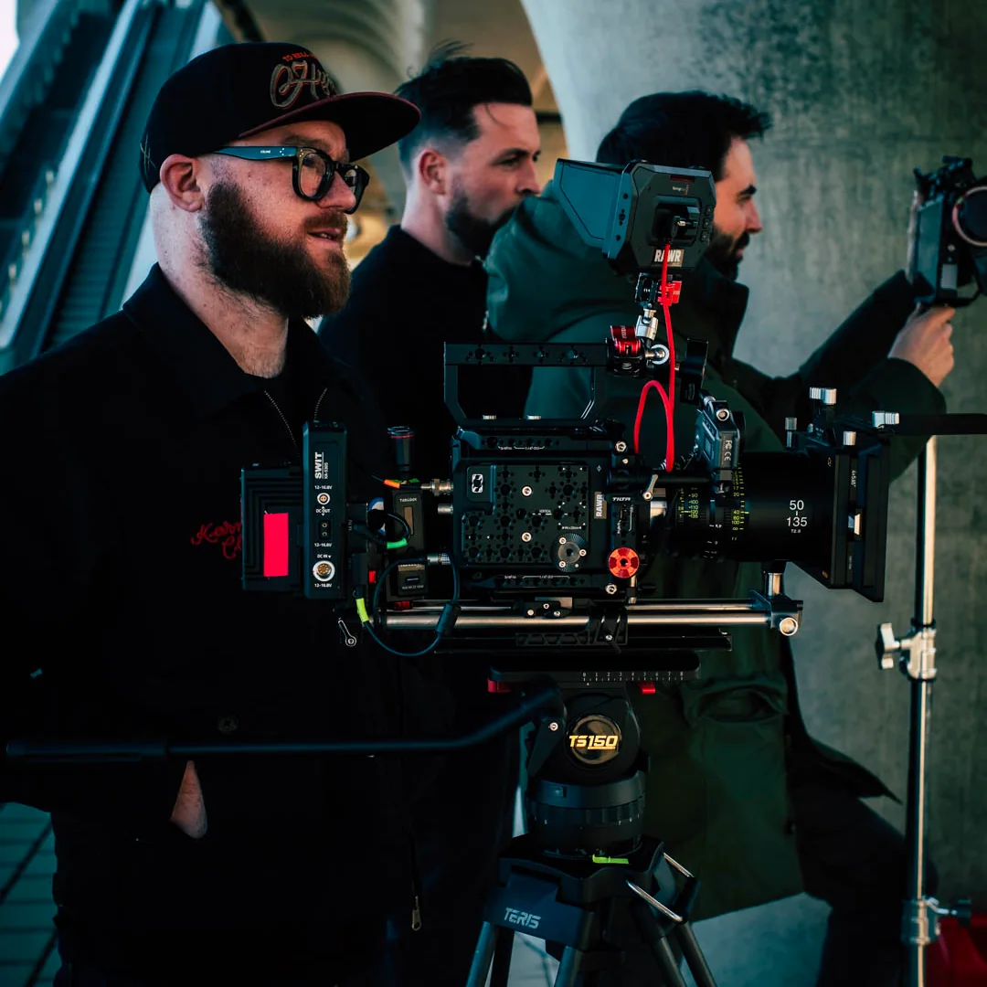 Deux membres d’une équipe technique autour d’une caméra cinéma pendant un tournage.