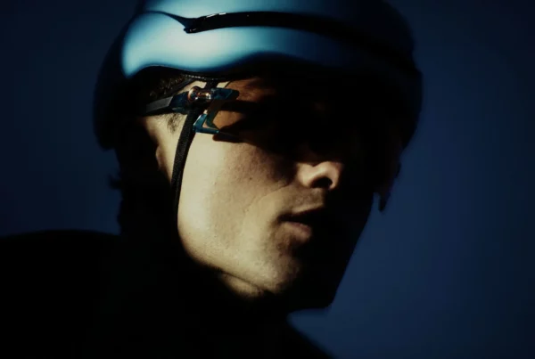 Portrait rapproché d’un cycliste équipé d’un casque dans une lumière bleutée pour la campagne Adris AXR2.