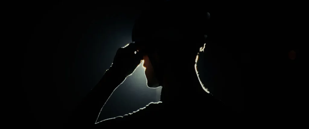 Silhouette rapprochée d’un cycliste Adris AXR2 en contre-jour, avec un éclat lumineux derrière le casque.