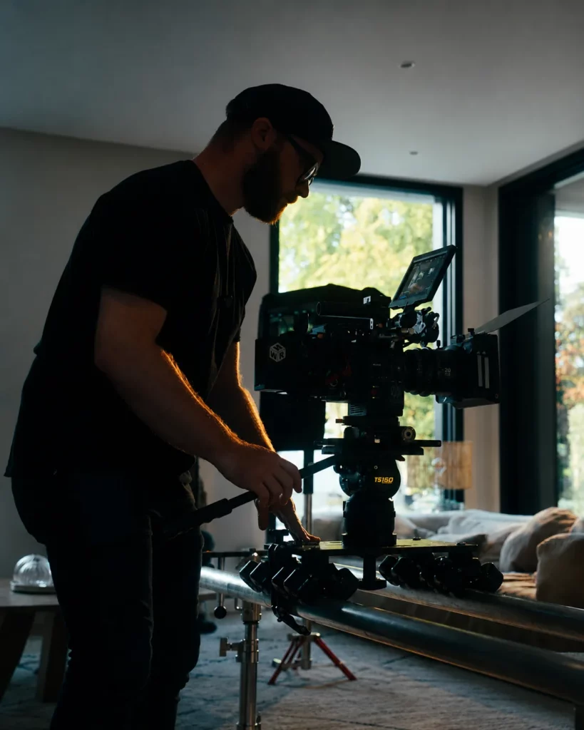Réalisateur manipulant une caméra sur travelling pendant un tournage vidéo professionnel.