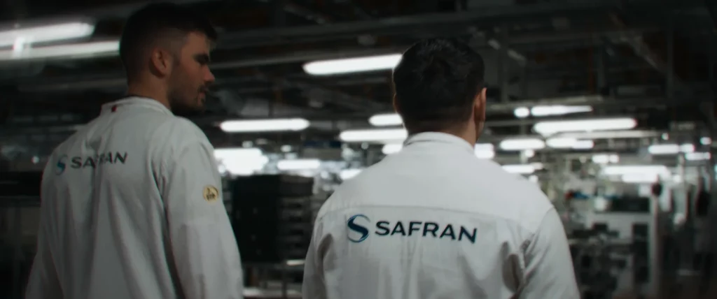 Deux apprentis en tenue de travail avançant dans une usine Safran pendant le tournage du film.