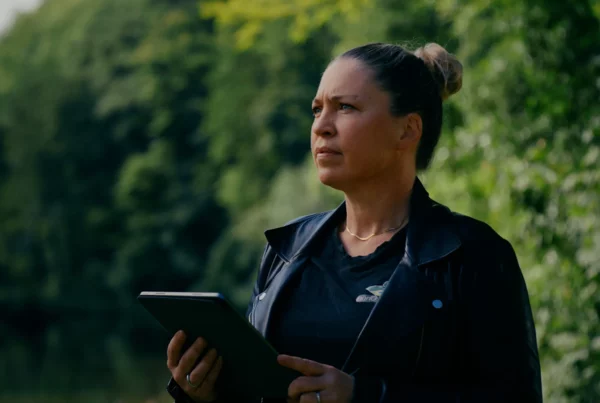 Virginie Labbé consultant une tablette sur le terrain pendant un chantier environnemental.