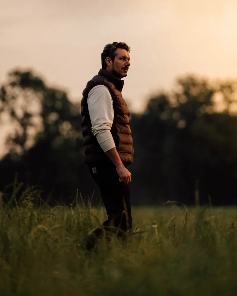 2026-ydeo-ensemble-formulons-votre-avenir-bts-champ-homme-coucher-soleil Homme debout dans un champ au coucher du soleil pendant le tournage du film YDEO Ensemble, formulons votre avenir.