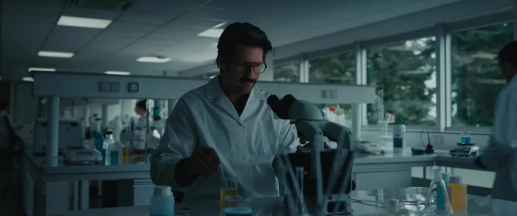 Homme en blouse blanche travaillant près d’un microscope dans un laboratoire, scène du film YDEO Ensemble, formulons votre avenir
